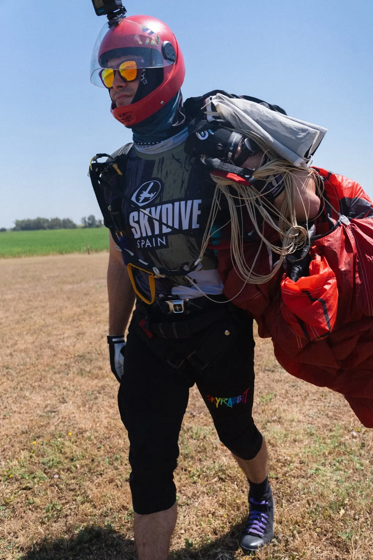 Skydiver wearing Skyrabbit shorts after landing with a packed canopy